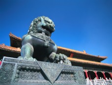 蓝天下古代建筑前的石狮子