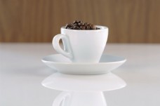 咖啡杯洁白杯内的咖啡豆图片