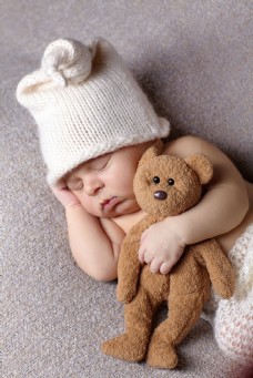 抱着小熊睡着的新生婴儿图片